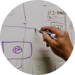 Eine Person zeichnet eine Skizze an ein Whiteboard